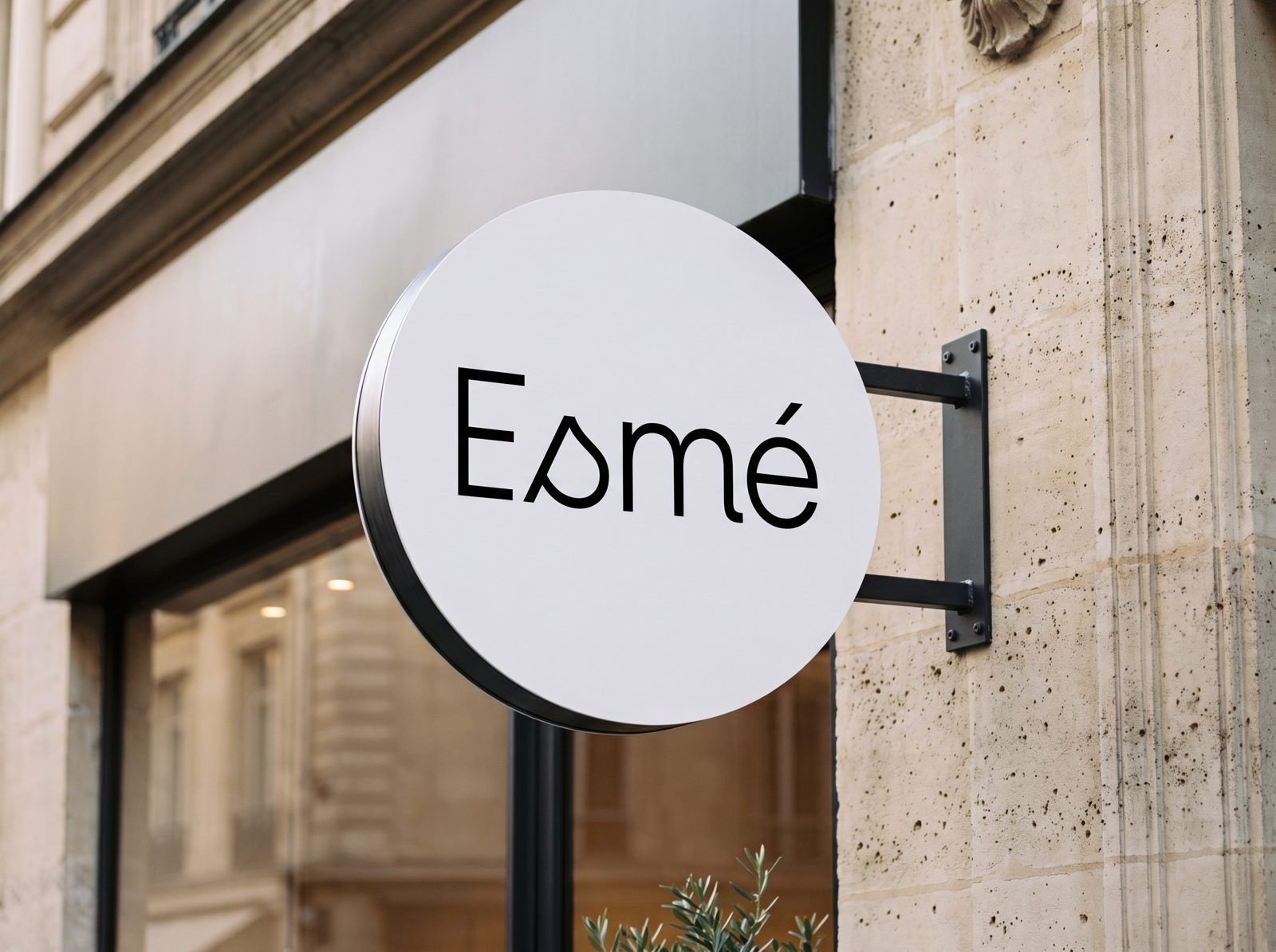 The round Esmé sign on the stone façade of a shopfront
